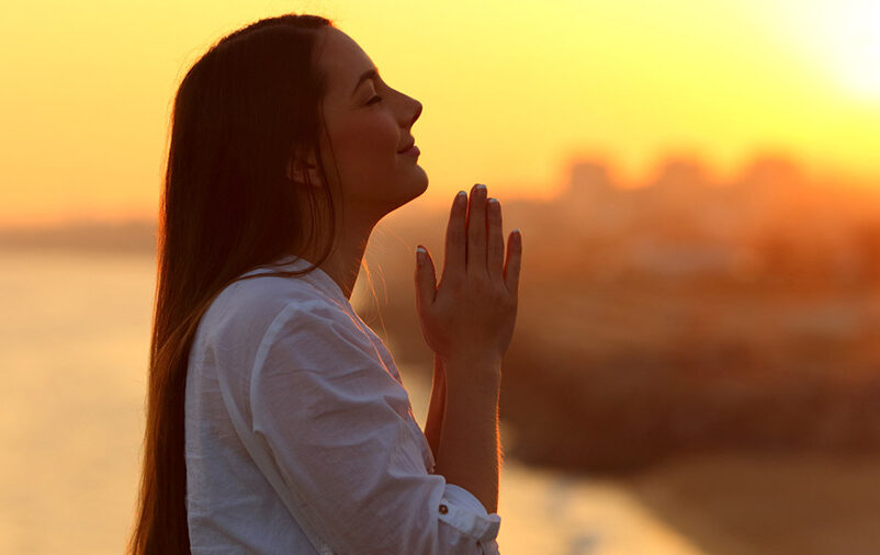 Mulher ora aos céus para saber como transformar saudade em gratidão