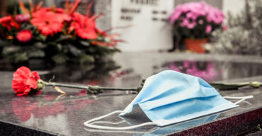 máscara em um túmulo no cemitério representa as facilidades funerárias necessárias na pandemia
