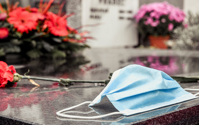 máscara em um túmulo no cemitério representa as facilidades funerárias necessárias na pandemia