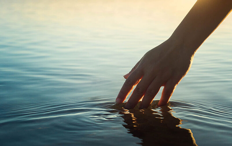 mão na água e pensando sobre Despedidas Em Diferentes Culturas
