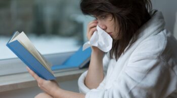 Mulher chora enquanto lê um livro, mostrando a dor dos personagens de livros mortos.