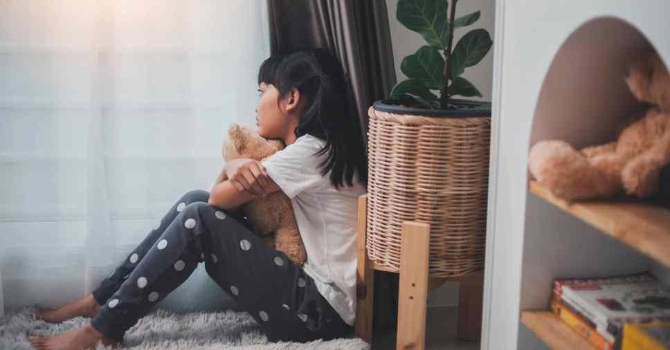Foto de perfil de criança com pelúcia em momento de terapia pós-luto na infância e introspecção.
